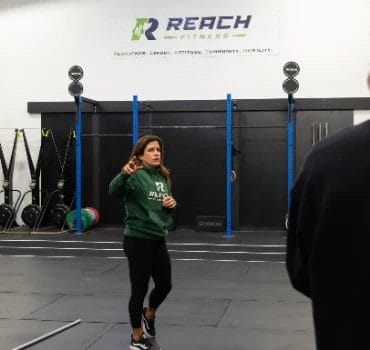 REACH Fitness Coach Explaining Something